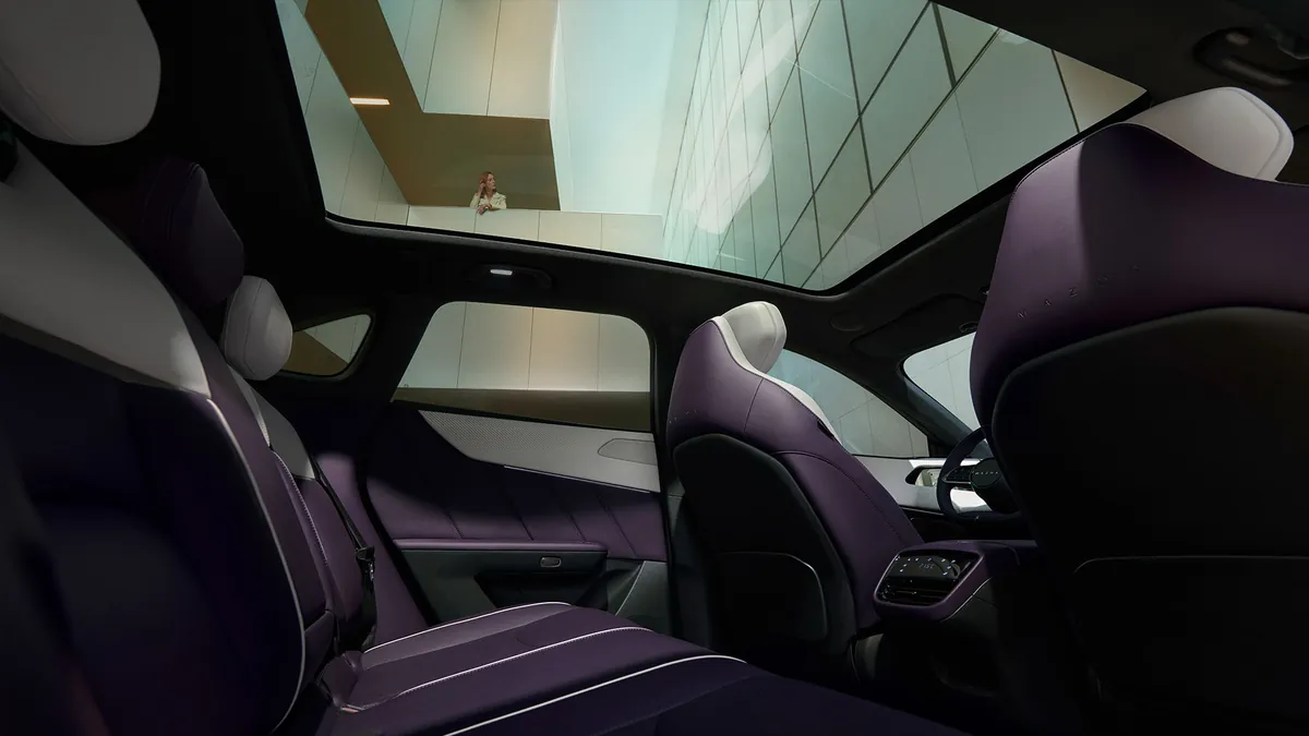 Interiören i Mazda CX-6e med ljus klädsel och panoramatak