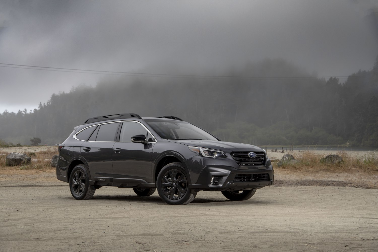 Svart Subaru Outback utanför skogsmiljö design