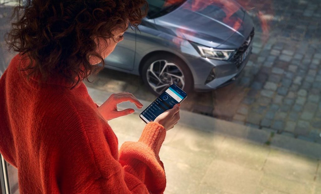 Hyundai i20 kvinna med smartphone uppkoppling bluelink