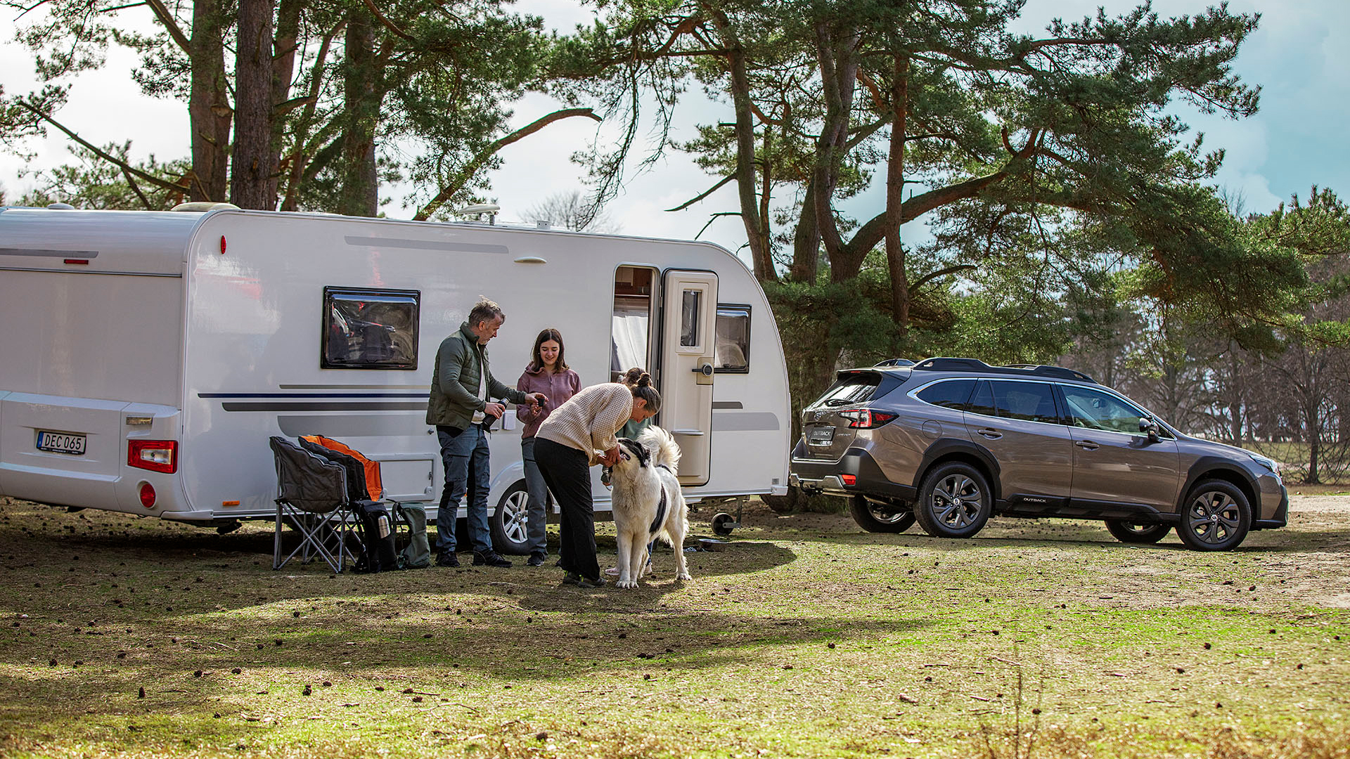Subaru Outback med Husvagn tillkopplad och familj med hund