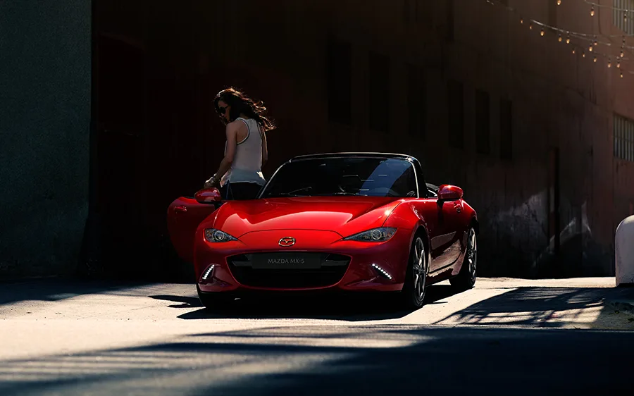 Röd Mazda MX-5 Parkerad i stadsmiljö och kvinna kliver ur