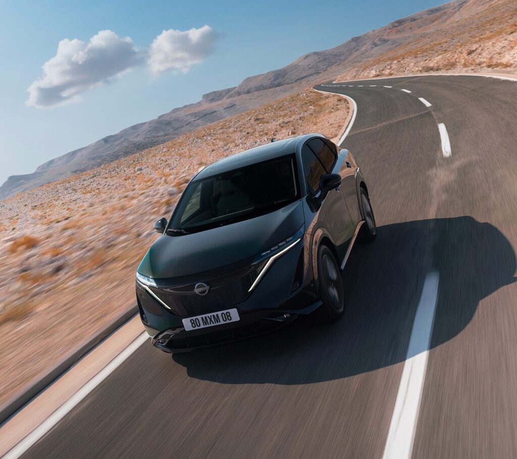 Nissan Ariya i grön färg kör längs landsväg