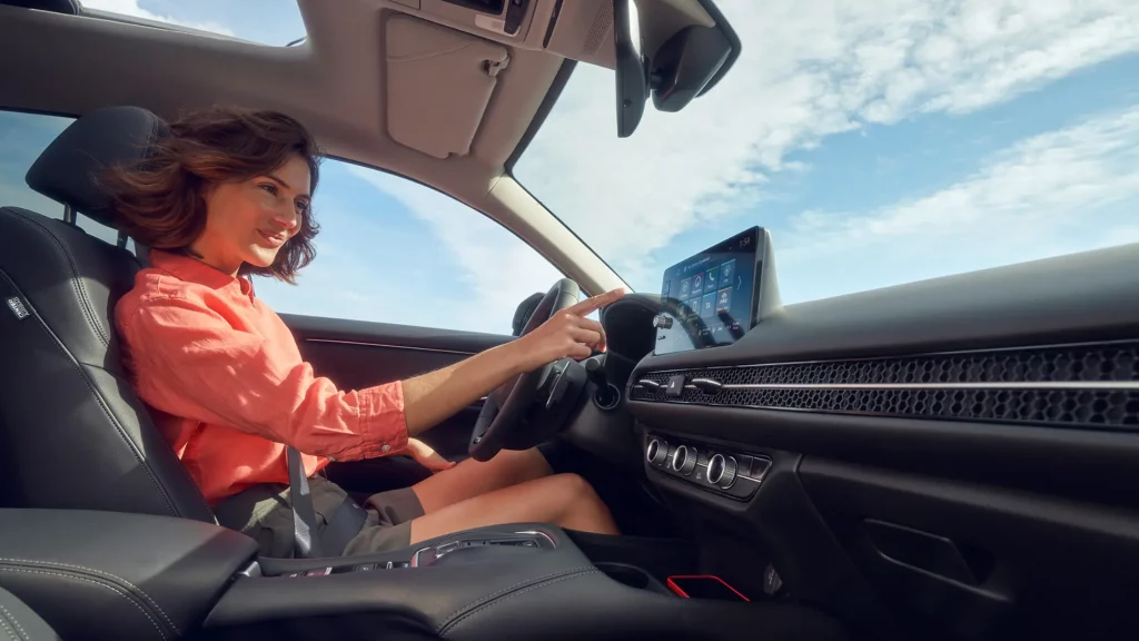 en glad tjej sitter bakom ratten på en Honda ZR-V Advance med öppet panoramatak