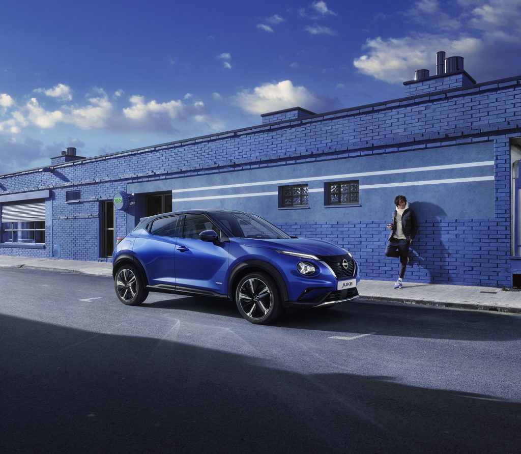 Nissan Juke exteriörbild blå med blå tegelvägg i bakgrunden

