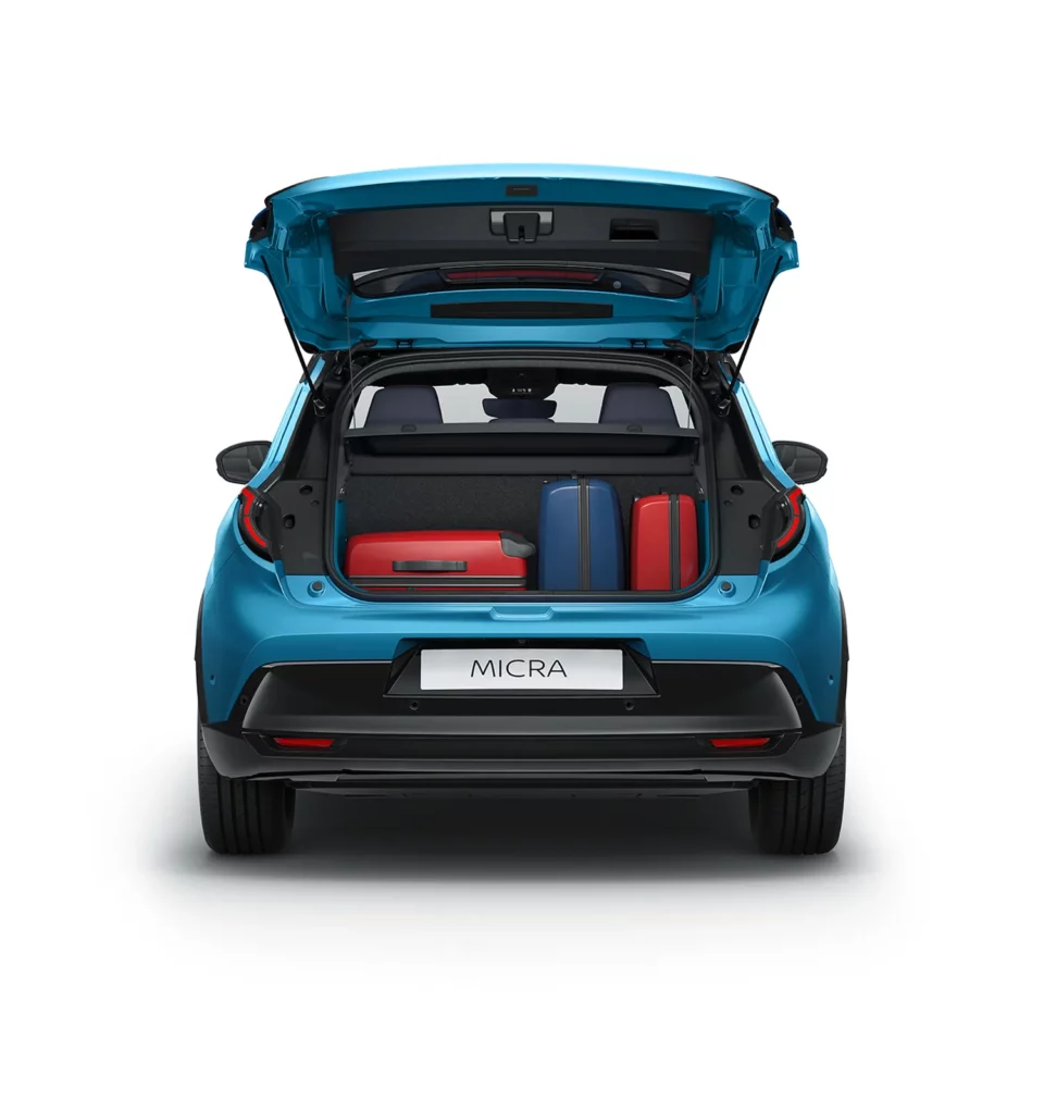 Nya Nissan MICRA i blå färg sedd rakt bakifrån med bagagelucka öppen och väskor inuti.